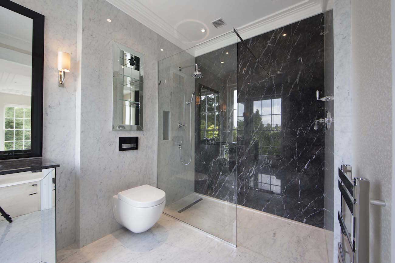 Renovated bathroom with a dark stone feature wall and frameless glass shower