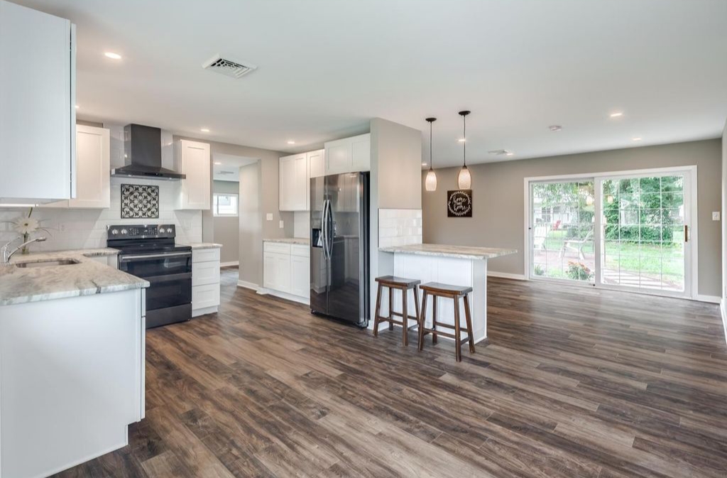 Renovated kitchen with an island, pendant lighting and full height cabinetry