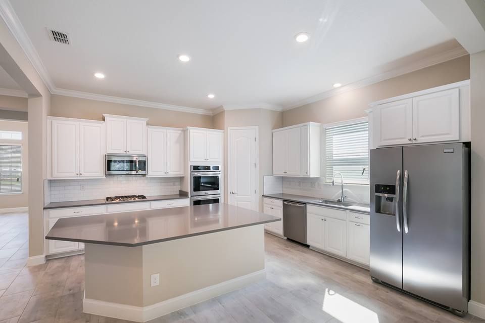White kitchen with a large island and stainless appliances