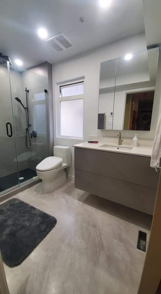 Bathroom vanity with a wide mirror and tiled surround